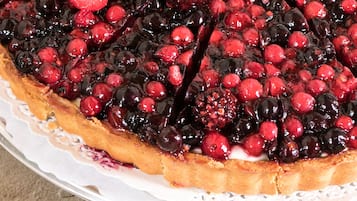 Gros plan d’une tarte aux fruits, avec une croûte dorée et une garniture de fruits brillants.