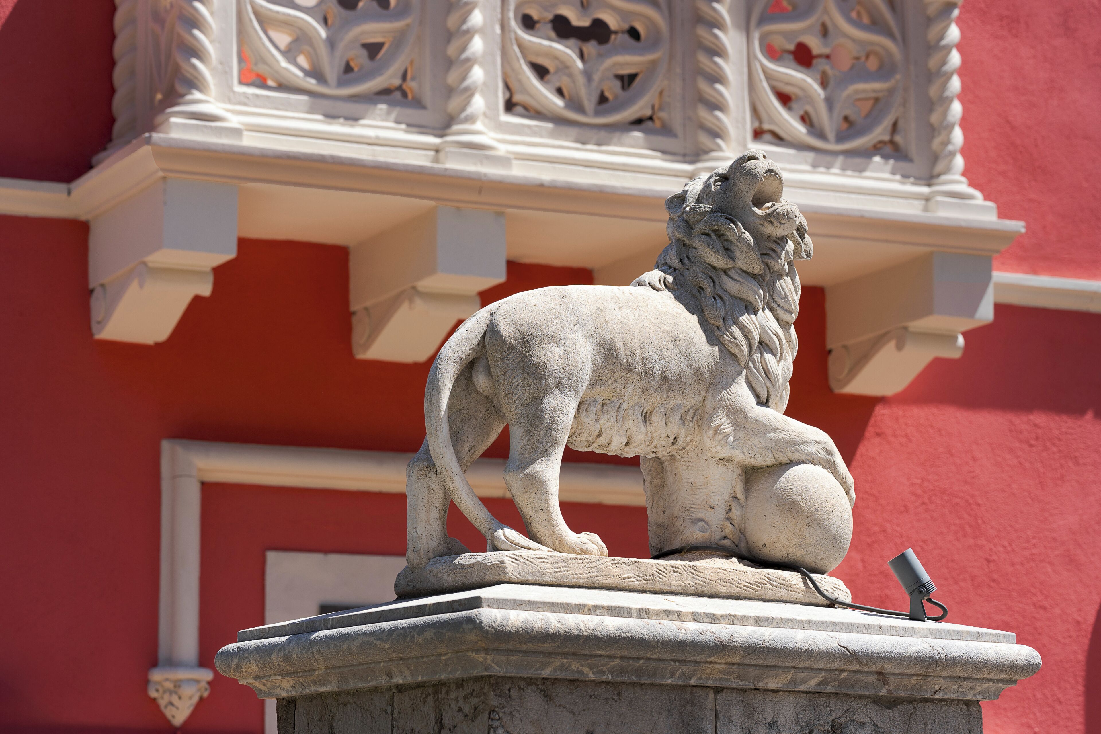 Una estatua de león de piedra sobre un pedestal.