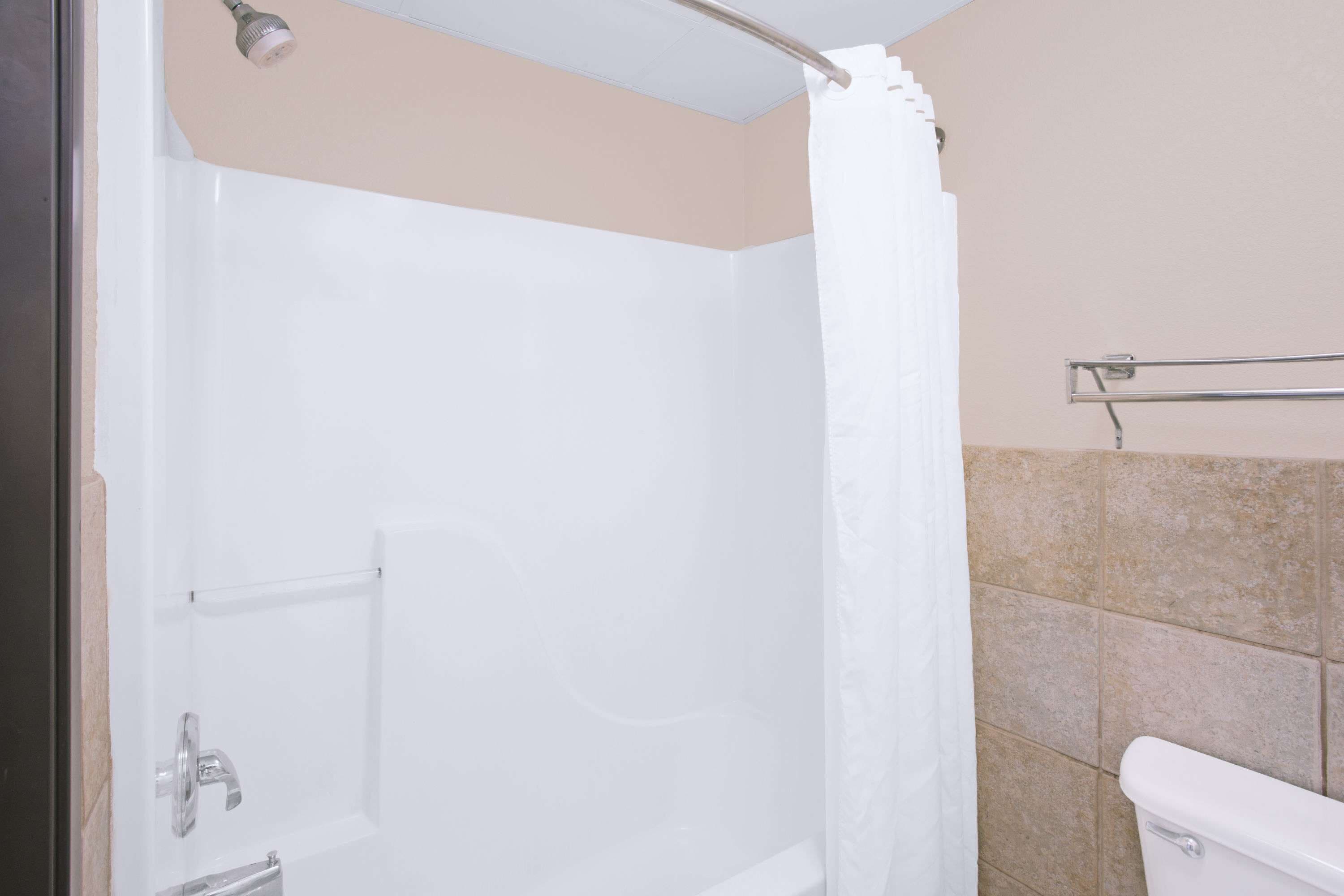 Un baño con ducha, inodoro y perchero para toallas.