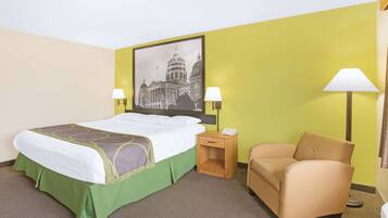 A hotel room with a bed, two bedside lamps, a chair, a nightstand, and a wall-mounted lamp.