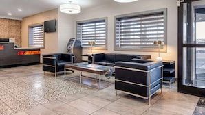 A modern hotel lobby with a reception desk, seating area, and large windows. - Best Western Louisville Airport Expo (Louisville)
