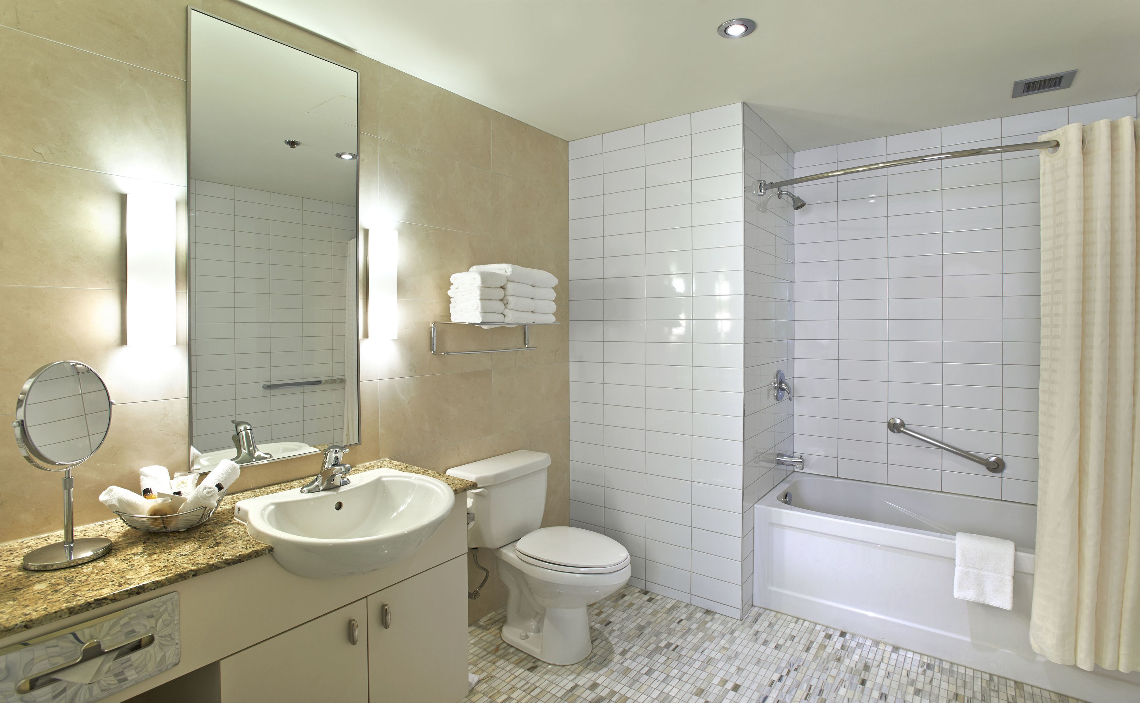 A modern bathroom with a sink, toilet, and bathtub.