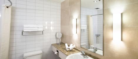 A modern bathroom with a toilet, sink, and large mirror.