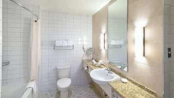 A modern bathroom with a shower, toilet, sink, and a large mirror.