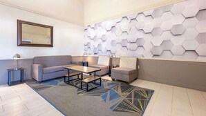 A modern living room with a sofa, two armchairs, a coffee table, and a patterned rug.