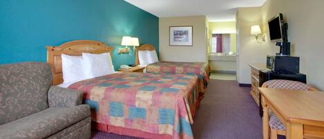 A hotel room with a bed, a sofa, a desk, and a television.