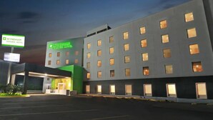A Wyndham Garden Hotel with a modern facade, multiple windows, and a well-lit entrance. - Wyndham Garden Monterrey Valle Real (Monterrey)