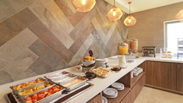 A buffet area with various food items and a coffee station. - Wyndham Garden Monterrey Valle Real (Monterrey)