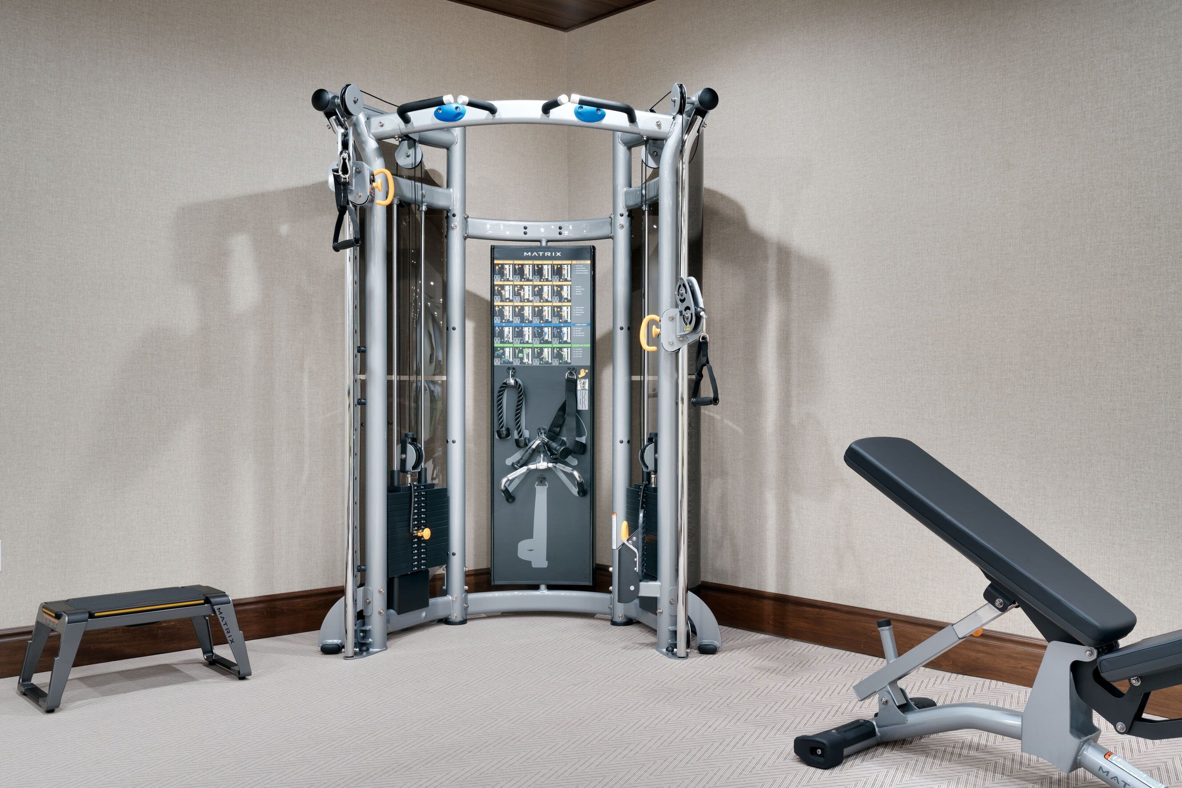 A gym with a pull-up bar, a bench, and a weight stack.