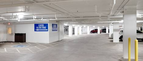A spacious parking garage with clear signage for elevators, ski & bike storage, and electric vehicle charging.