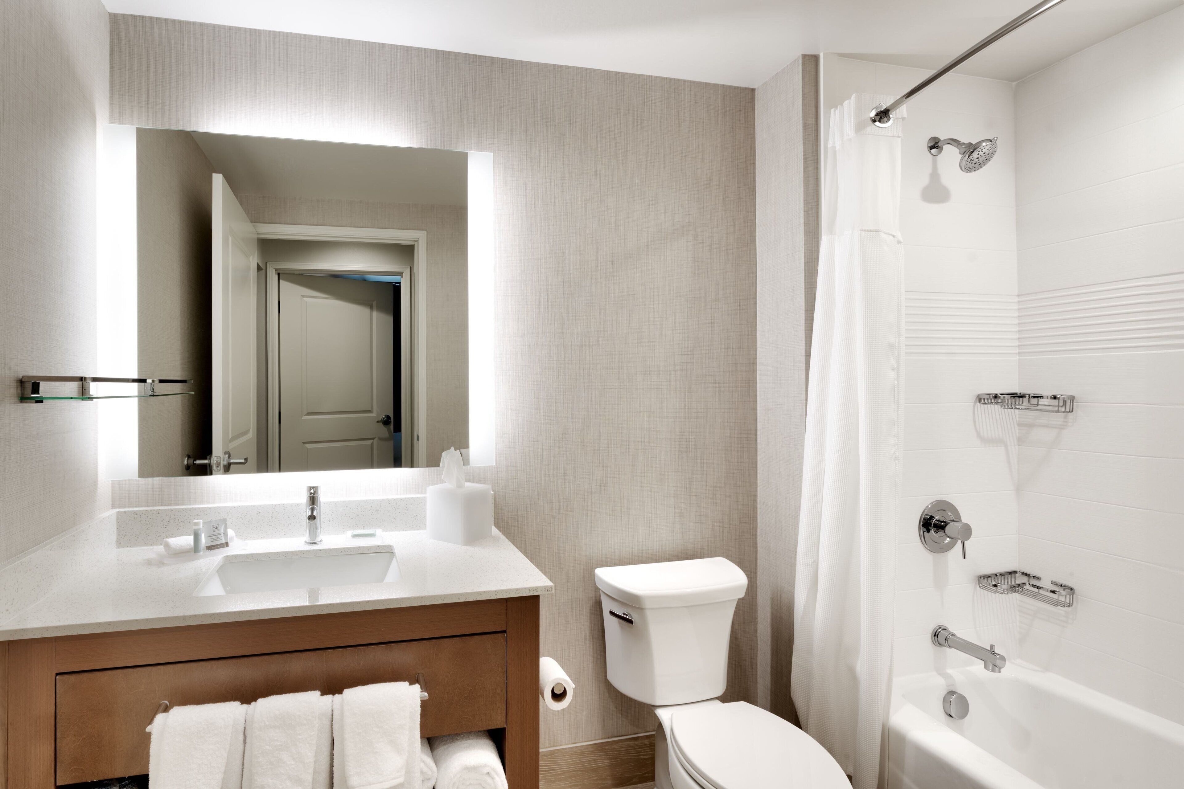 Une salle de bain moderne équipée d’un lavabo, de toilettes et d’une douche.
