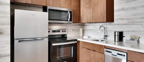 Uma cozinha moderna com eletrodomésticos de aço inoxidável, armários de madeira e painel de fundo de mármore.
