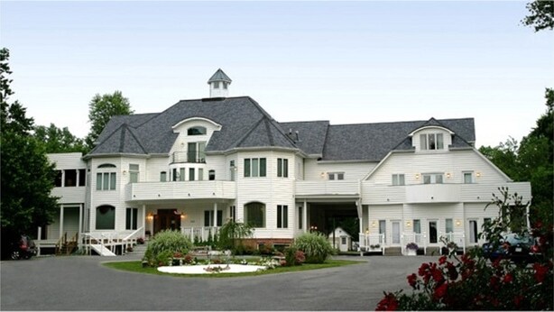 A large, two-story house with a central entrance, multiple windows, and a sloped roof. - The Columbia Inn at Peralynna Manor (Columbia)