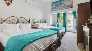 A hotel room with two beds, a chandelier, an air conditioner, a painting, and a view of the outdoors. - The Columbia Inn at Peralynna Manor (Columbia)