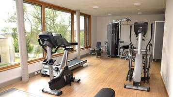 A gym with treadmills, a weight machine, and a bench.