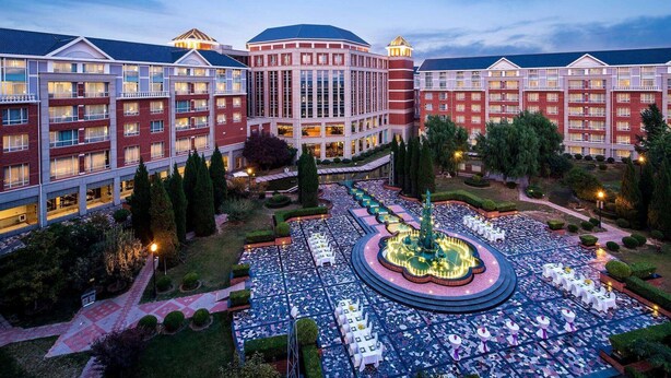 A hotel with multiple buildings, a central courtyard with a fountain, and outdoor seating areas. - Wyndham Beijing North Hotel (Beijing)