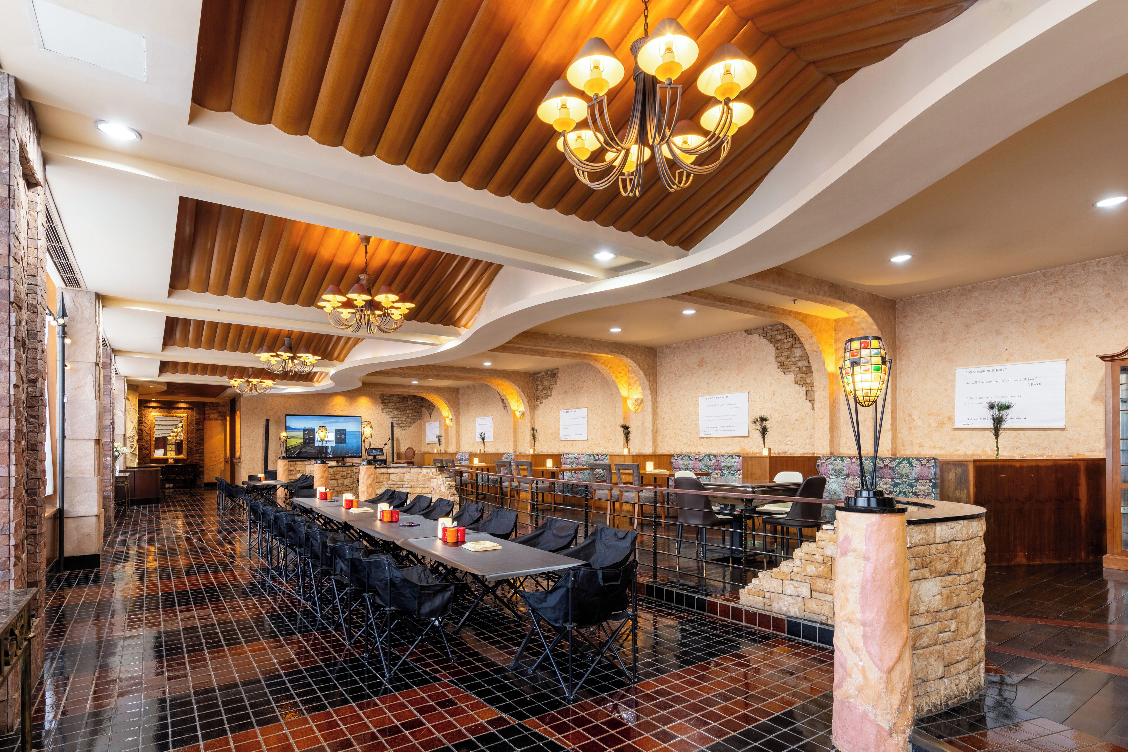 A spacious conference room with a long table, multiple chairs, and a stone pillar.