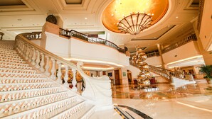A grand staircase with ornate railings and a large chandelier in a spacious lobby. - Wyndham Beijing North Hotel (Beijing)