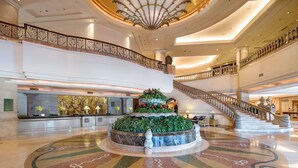 A grand lobby with a central fountain, a high ceiling with a decorative fan, and a grand staircase. - Wyndham Beijing North Hotel (Beijing)
