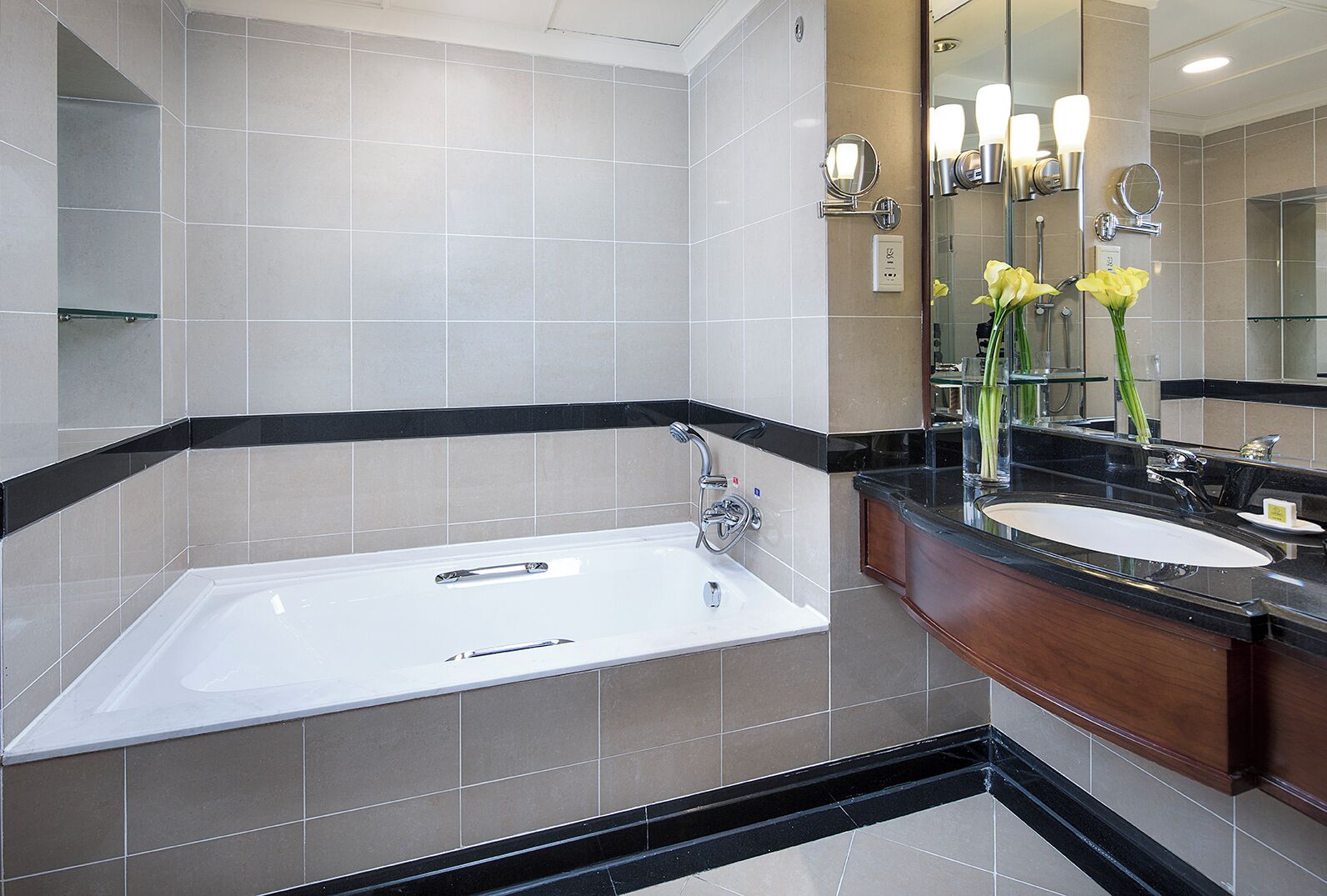 A modern bathroom with a freestanding bathtub, a vanity with a sink, and a large mirror.