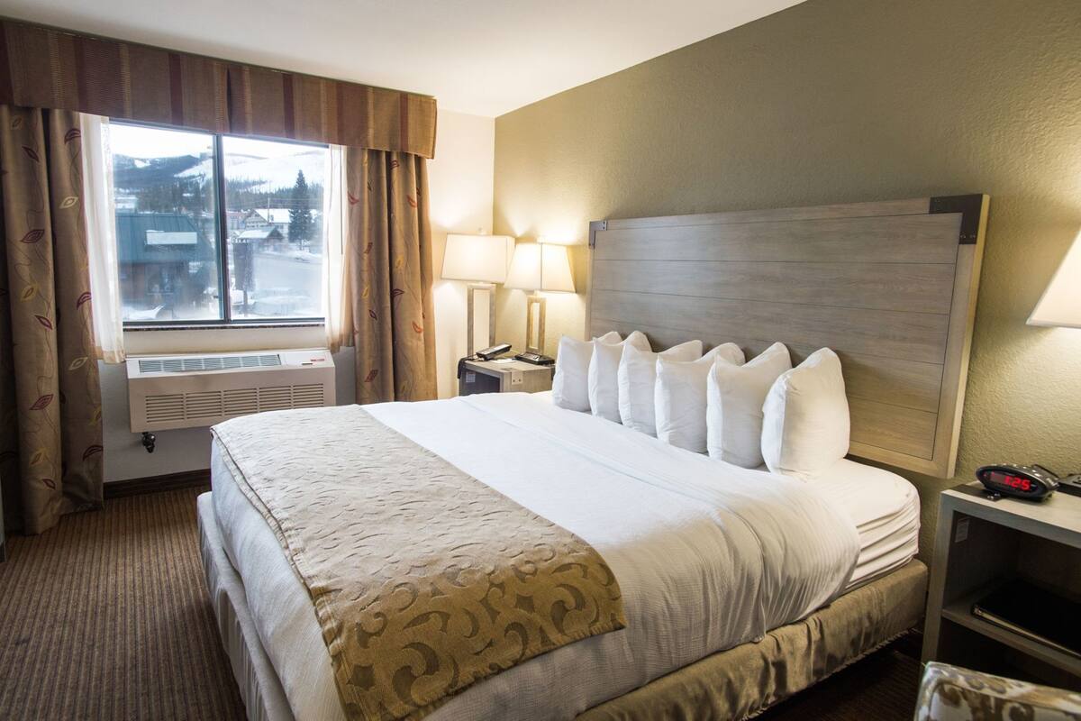 Escritorio, cortinas blackout y tabla de planchar con plancha