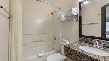 A bathroom with a bathtub, toilet, and sink.