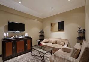 Suite, 1 cama de matrimonio grande | Zona de estar | Televisión LCD de 32 pulgadas con canales digitales, una televisión