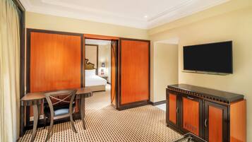 Una habitación de hotel con una cama, un escritorio, una silla, un televisor y un armario.