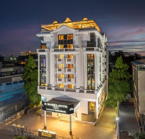 A modern hotel with a prominent sign, multiple balconies, and a pool area. - St. Marks Hotel Bengaluru, a member of Radisson Individuals (Bengaluru)