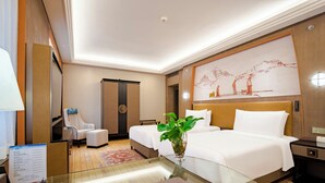 A hotel room with a large bed, two bedside tables, a chair, a desk, and a large painting on the wall. - Xizang Hotel Chengdu (Chengdu)