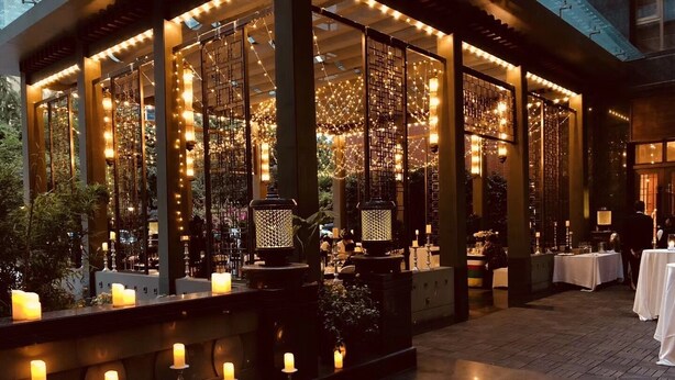 An outdoor dining area with tables, candles, and string lights. - Xizang Hotel Chengdu (Chengdu)