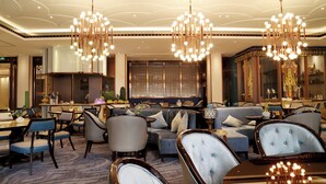 A spacious hotel lobby with a central seating area, multiple dining tables, and a large decorative mirror. - Xizang Hotel Chengdu (Chengdu)