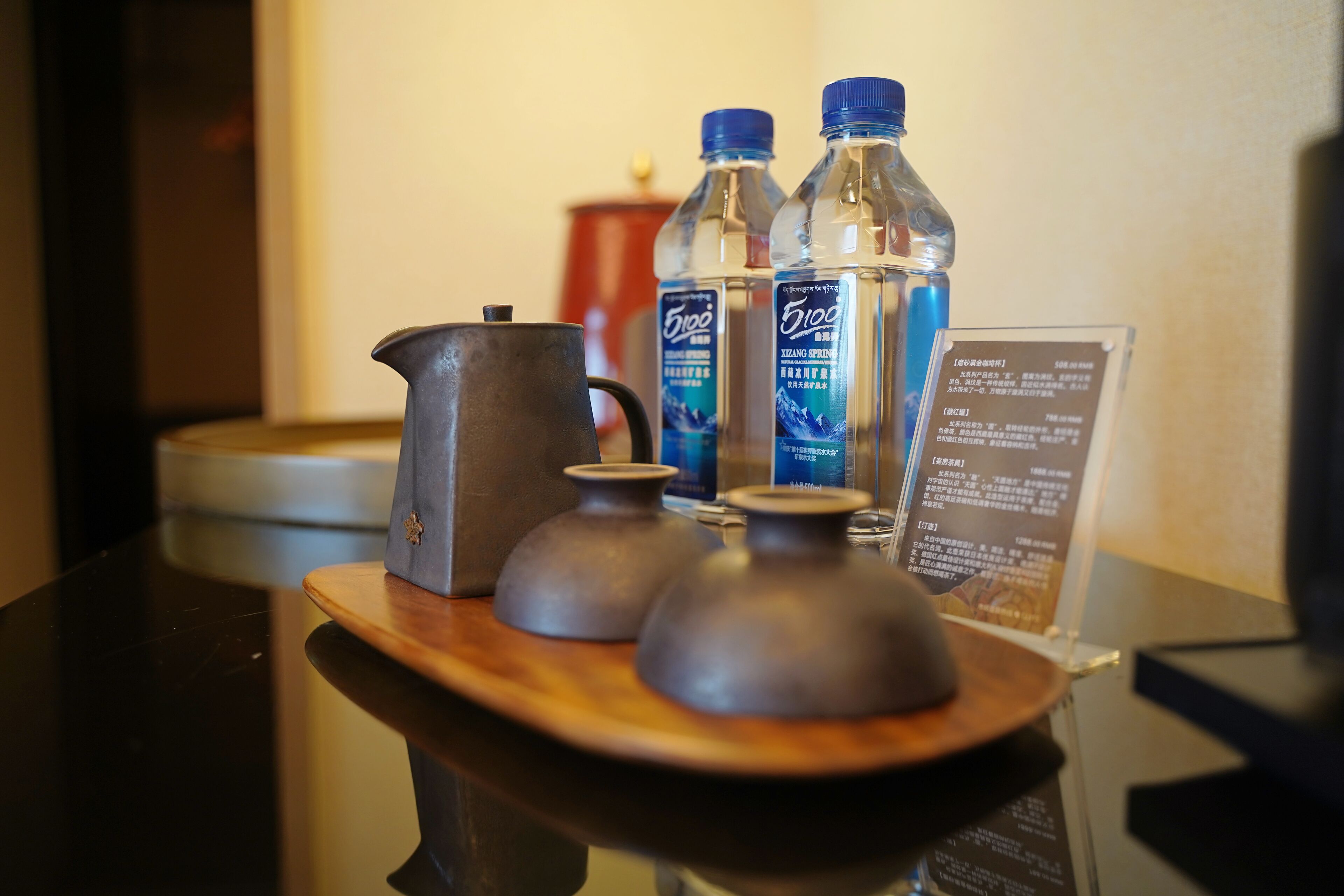 Ein Tisch mit einem Teekessel, zwei Wasserflaschen und einem Schild.