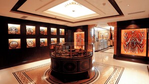 A lobby with a central display case, framed artwork on the walls, and a patterned floor. - Xizang Hotel Chengdu (Chengdu)