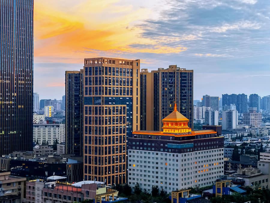 A high-rise building with a distinctive golden dome and a modern glass facade.
