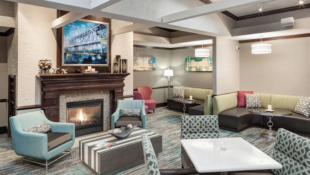 A modern hotel lobby with a fireplace, seating areas, and artwork on the walls. - Residence Inn by Marriott Kansas City Country Club Plaza (Kansas City)
