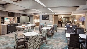 A hotel lobby with a bar, seating area, and a piano. - Residence Inn by Marriott Kansas City Country Club Plaza (Kansas City)