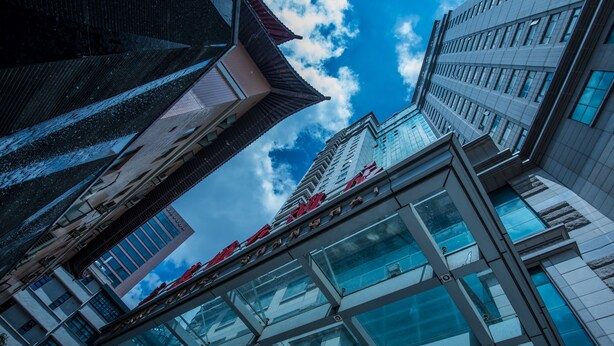 A modern building with a glass facade and a traditional roof. - Merry Hotel Shanghai (Shanghai)