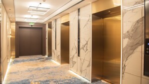 A hallway with marble walls and elevators. - Merry Hotel Shanghai (Shanghai)