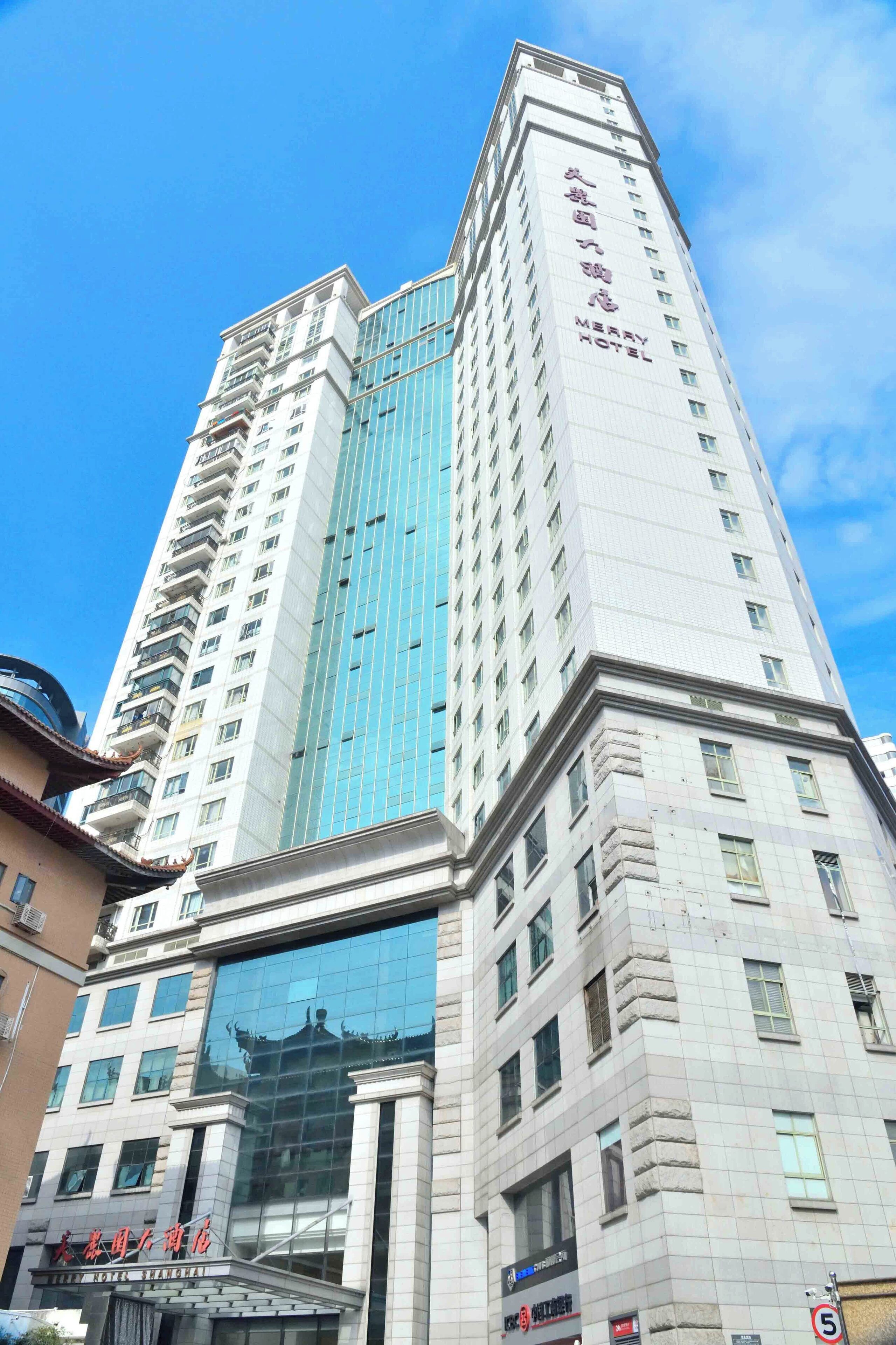 Un hotel alto con fachada de vidrio moderna y elementos arquitectónicos tradicionales en la base.