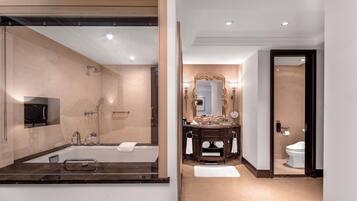 Un baño moderno con un espejo grande, una bañera, un lavabo y un inodoro.