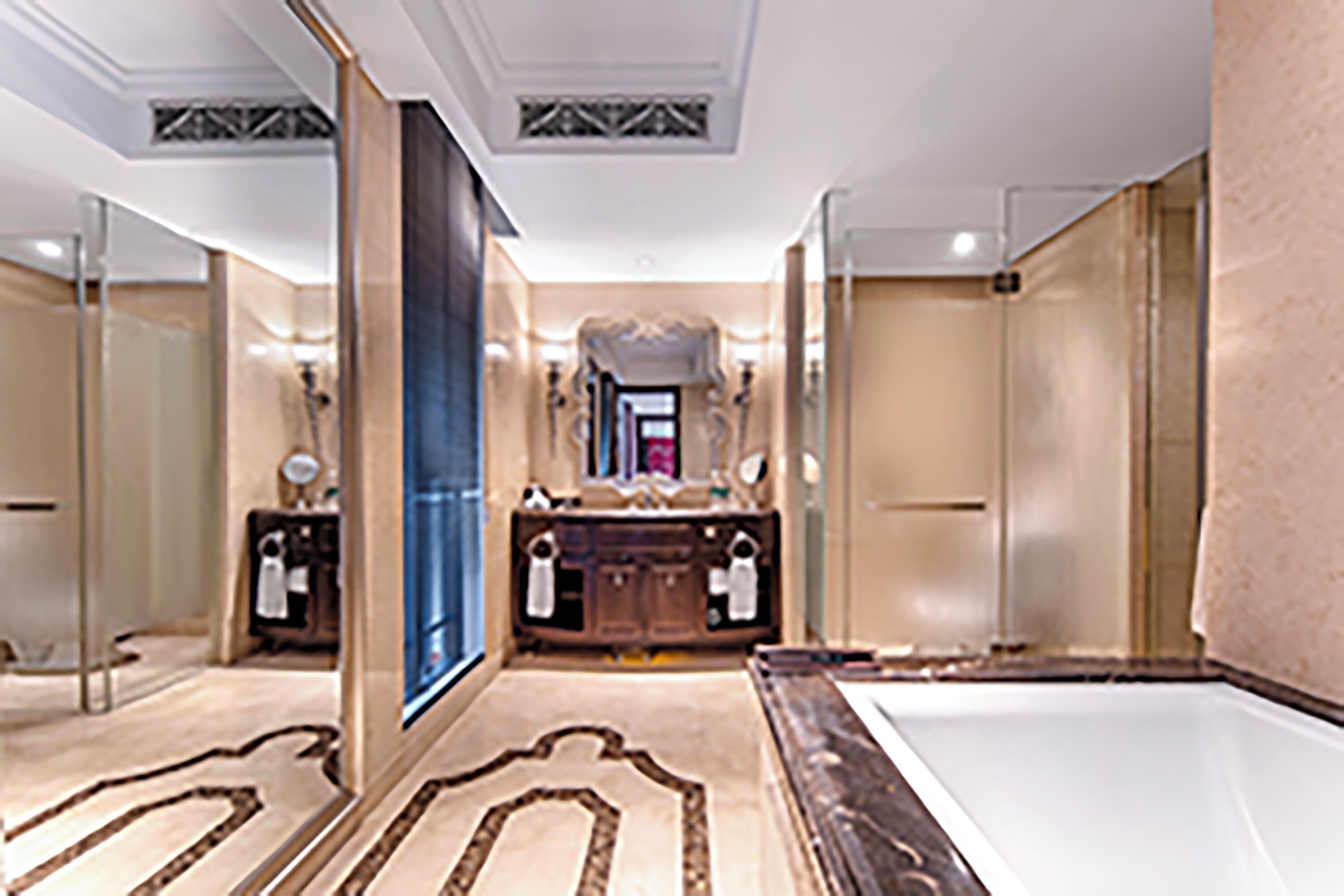 A luxurious bathroom with a large mirror, a bathtub, and a vanity with a sink.