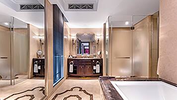 A luxurious bathroom with a large mirror, a bathtub, and a vanity with a sink.