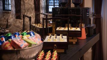 A buffet table with various food items and a coffee machine.