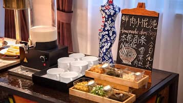 Een buffetopstelling met diverse gerechten en een koffieapparaat.