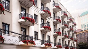 Un edificio con varios balcones decorados con flores rojas.