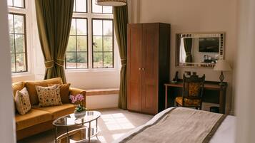 A hotel room with a bed, a sofa, a desk, and a wardrobe.