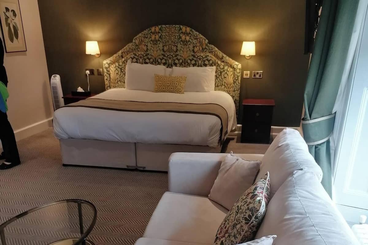 Une chambre d’hôtel avec un grand lit, un canapé et une petite table.