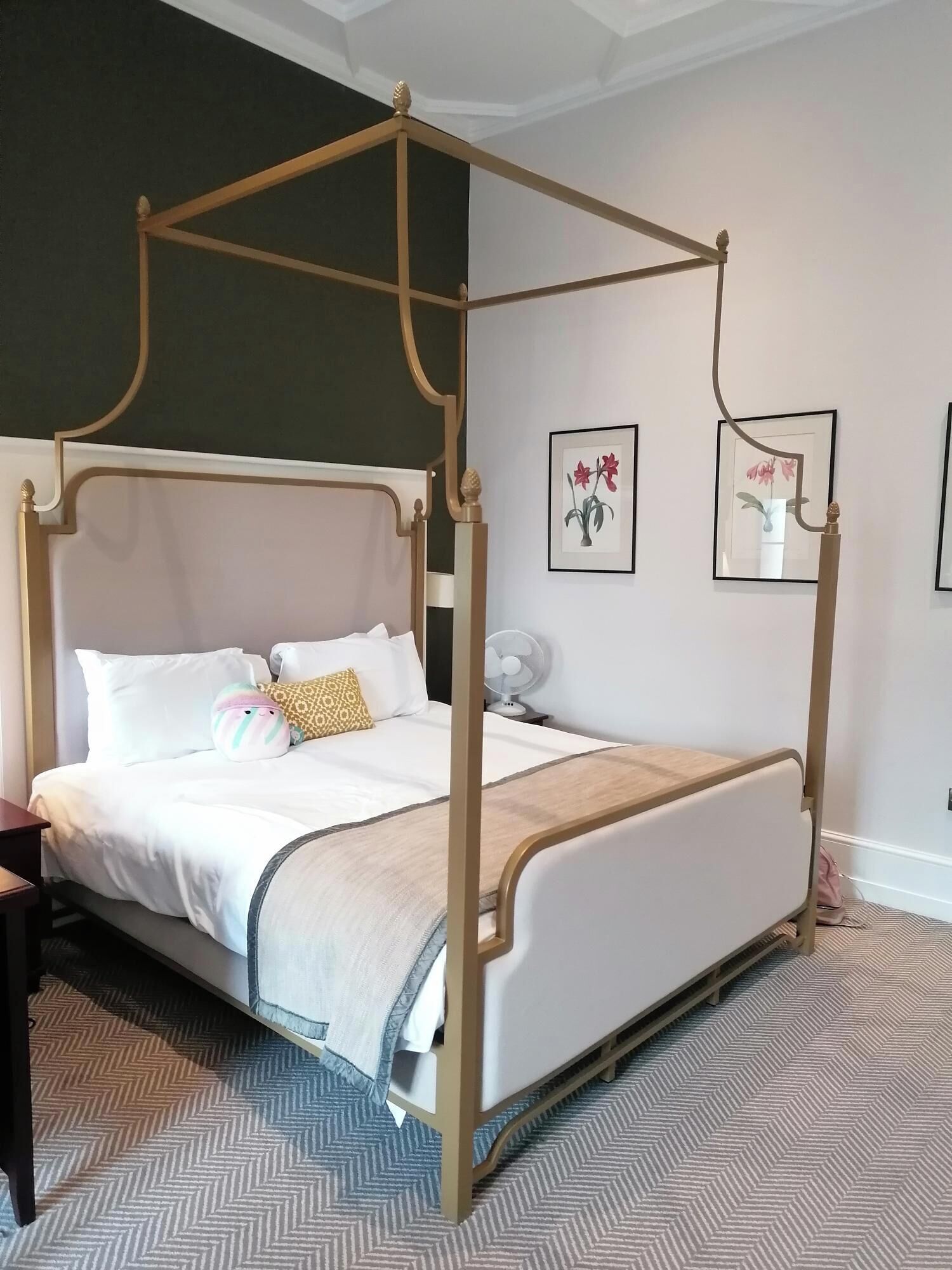 Una cama con dosel, ropa de cama blanca y almohadas decorativas.