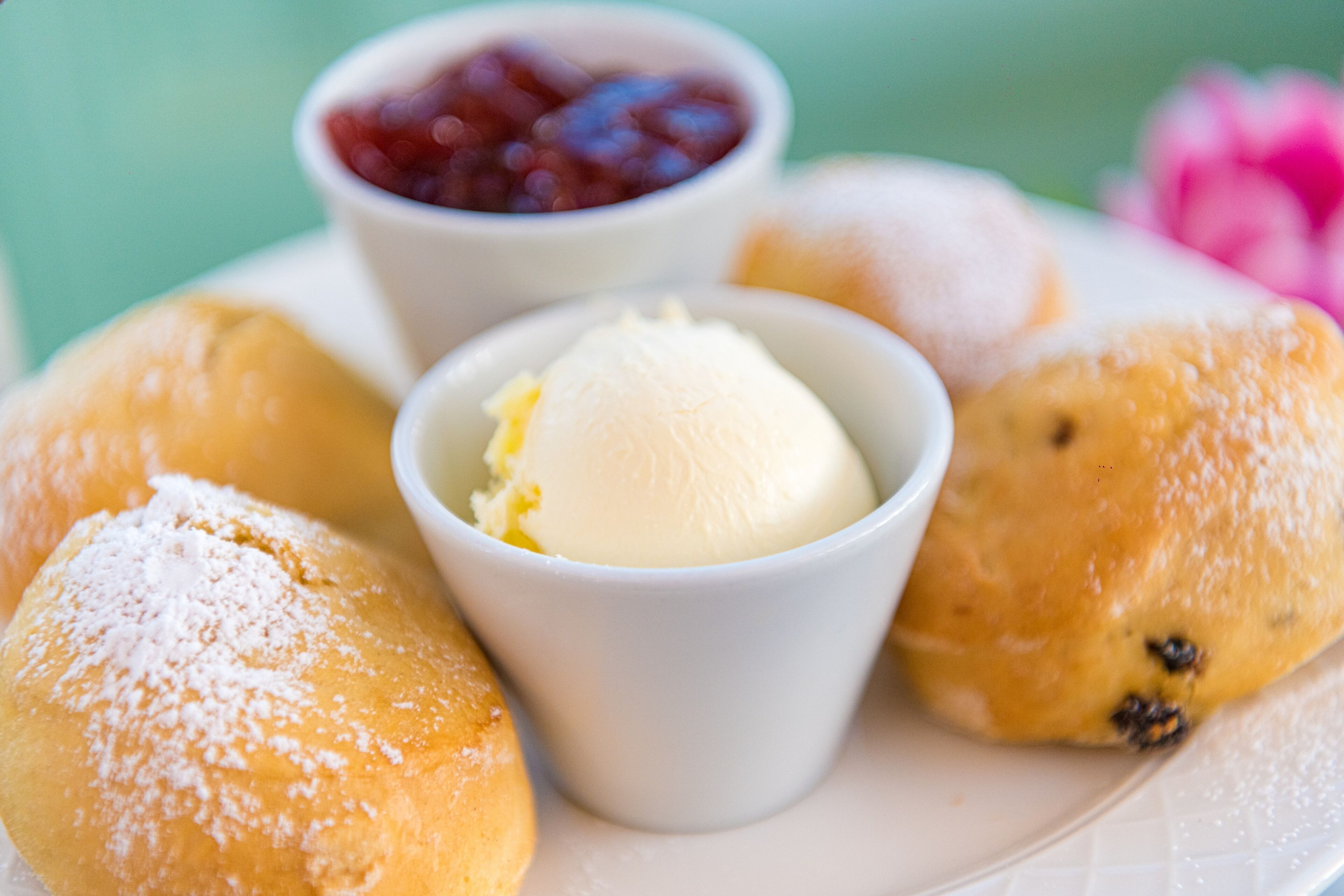 Un plato de pasteles con una bola de helado y un pequeño recipiente de mermelada.